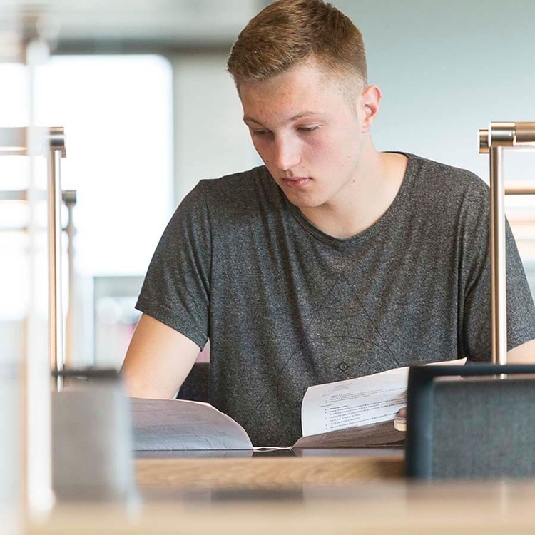 Student sitting at desk reading through material