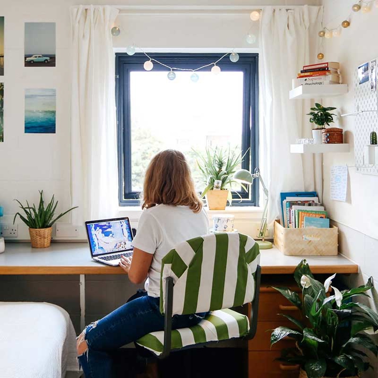 Student sitting at a desk in their room