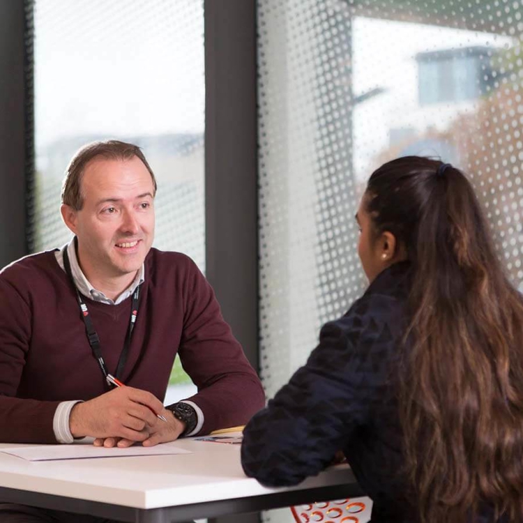 support staff talking with student